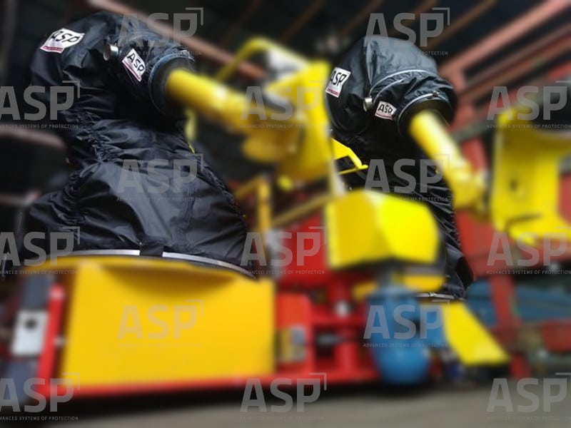 zwei gelbe Industrieroboter FAnuc nebeneinander, geschützt durch zwei schwarze Roboterhüllen in ATEX-Umgebungen mit explosiver Atmosphäre